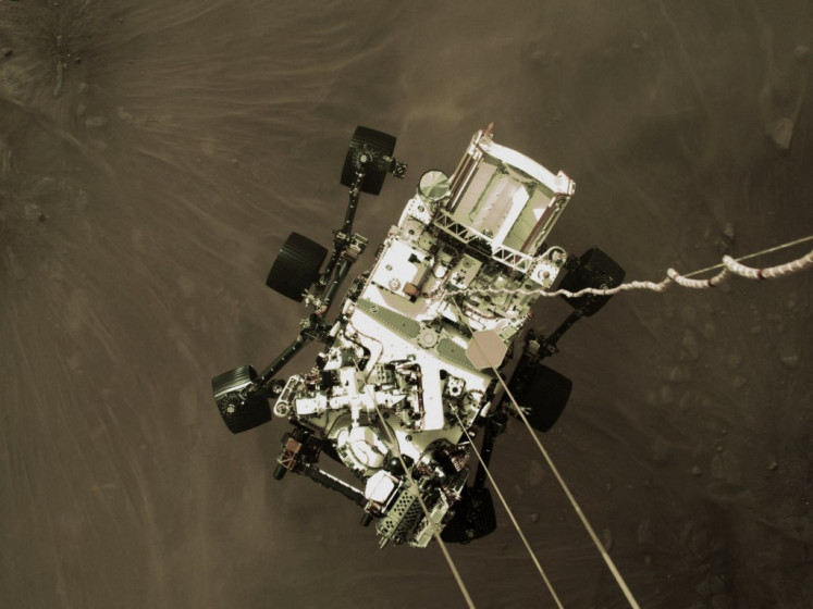This photo released by NASA, shows the Perseverance rover being lowered by the Sky Crane to the surface of Mars on February 18, 2021. NASA said February 18, 2021 that the Perseverance rover has touched down on the surface of Mars after successfully overcoming a risky landing phase known as the 