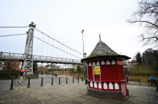 A cyclist passes under the Queen's Park Bridge across the River Dee in Chester, north west England on February 21, 2021 as life continues in Britain's third coronavirus lockdown. 
