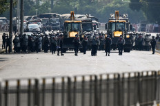 Police advance towards protesters demonstrating against the military coup in Yangon on February 22, 2021. 