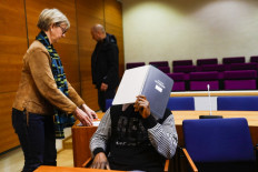 A man from Sierra Leone accused of committing serious war crimes and crimes against humanity during Liberia's bloody civil war, hides his face at the custody hearing at the Pirkanmaa District Court in Tampere, Finland, on March 12, 2020. - The Sierra Leonean citizen, born in 1969, is alleged to have carried out 
