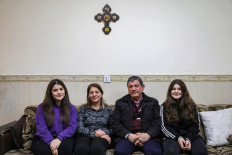 Haval Emmanuel (second right), an Iraqi Chaldean Christian and civil servant who is waiting for the greenlight to emigrate to Canada with his family, poses for a photo with his wife and children at their home in Arbil, the capital of Iraq's northern autonomous Kurdish region, on Feb. 1.