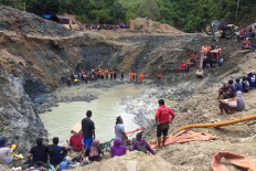 Rescue teams conduct a search for miners buried by a landslide at an illegal gold mining operation in the village of Buranga in Parigi Moutong Regency, Central Sulawesi on February 25, 2021. 