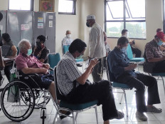 Elderly people sit distanced from one another as they wait their turn for a pre-COVID-19 vaccination screening at a community health center (Puseksmas) in Palmerah, West Jakarta, on Feb. 25. The government aims to inoculate some 21 million people aged 60 and above, but global supply shortages threaten to delay vaccine deliveries to Indonesia and elsewhere.