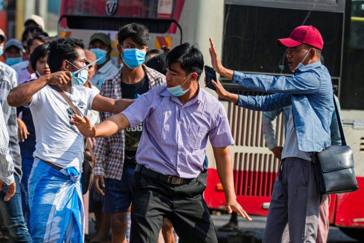 A military supporter points a sharp object as he confronts pro-democracy protesters during a military support rally in Yangon, Myanmar, February 25, 2021.