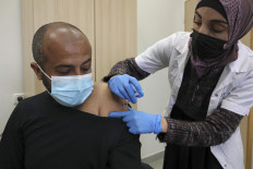 A healthcare worker administers a shot of the Pfizer-BioNtech Covid-19 vaccine to a man at a clinic in the Negev's main Bedouin town of Rahat, on Feb. 17. Deep in the Negev desert, Bedouin residents of villages deemed illegal by Israel say more houses have been demolished than people vaccinated, despite the Jewish state's world-beating coronavirus inoculation drive.