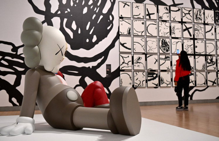 The exhibition chronicles KAWS's twenty-five-year practice, featuring graffiti drawings, paintings, smaller collectibles, furniture, recent augmented reality projects, and sculptures.