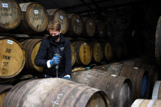 Employee Matthew Coulson poses for a photograph with whisky casks in the bonded warehouse at The Glenturret Distillery in Crieff, central Scotland, on Feb. 26.