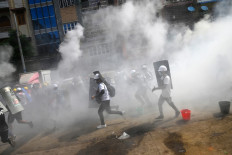 Protesters hold homemade shields as they run during a demonstration against the military coup in Yangon on March 3, 2021. 