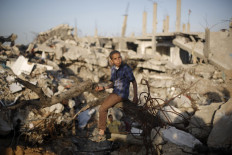 A Palestinian sits amid the rubble of buildings that were destroyed during the 50-day war between Israel and Hamas militants in the summer of 2014, in Gaza City's al-Shejaiya neighbourhood, on March 31, 2015. 