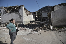 A woman stands by damaged old buildings in the village of Damasi, near the town of Tyrnavos, after a strong 6,3-magnitude earthquake hit the Greek central region of Thessaly on March 3.