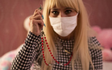 Gloria holds a cross and gestures as she describes the abuse she suffered while speaking during an interview at the shelter 