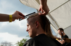 A fan has his hair cut during the mullet haircut festival in Boussu on May 18 2019. 
