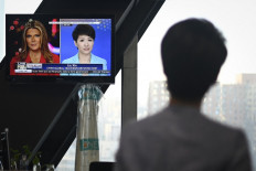 China's state broadcaster CGTN anchor Liu Xin looks at a screen showing her debate with Fox Business Network presenter Trish Regan, at the CCTV headquarters in Beijing on May 30, 2019.