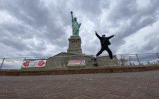 A man from Michigan jumps while he poses in front of Statue of Liberty in New York City on March 1, 2021. 