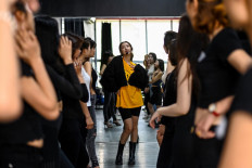 This photograph taken on March 2, 2021 shows instructor Pham Kieu Ly (center) demonstrating a pose to participants during a course teaching them how to pose for photographs on their mobile phones at a studio in Hanoi. 