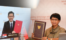 Indonesian Foreign Minister Retno LP Marsudi (right) and Singaporean Trade and Industry Minister Chan Chun Sing (left) hold the instrument of ratification of Indonesia-Singapore bilateral investment treaty (BIT) documents during an online meeting on Tuesday.