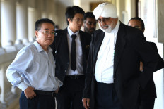 North Korean embassy counsellor Kim Yu Song (left) walks with Jagjit Singh (right), lawyer to Mun Chol Myong, the North Korean man facing extradition from Malaysia to the US on money-laundering, at the Session Court in Kuala Lumpur on December 13, 2019. 