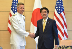 Admiral Philip S. Davidson (L), Commander of US Indo-Pacific Command, shakes hands with Japan's Prime Minister Shinzo Abe at Abe's office in Tokyo on June 21, 2018.
