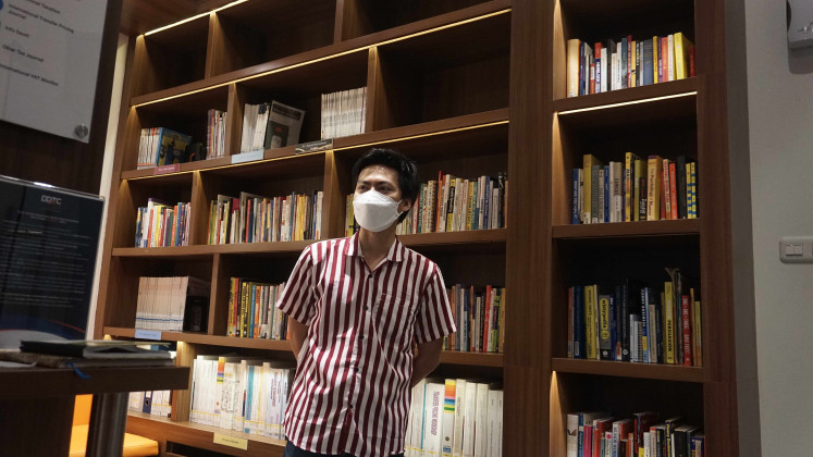 Ulwan Fakhry, peneliti komedi dari Institut Humor Modern Indonesia (IHIK) berdiri di depan buku-buku yang tersedia di Perpustakaan Studi Humor. 