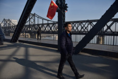 A man walks on the Yalu River Broken Bridge, with the Sino-Korean Friendship Bridge behind, in the border city of Dandong, in China's northeast Liaoning province on February 23, 2019. North Korean leader Kim Jong Un's train is expected to cross the Friendship Bridge on a journey across China before Kim's summit meeting with US President Donald Trump in Vietnam on February 27. 