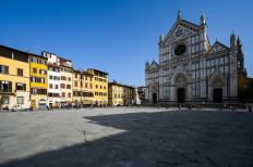 A photo taken on February 23, 2021 on Piazza Santa Croce in Florence shows a 1865 sculpture of Italian poet, writer and philosopher Dante Alighieri (Rear C-R), by Italian sculptor Enrico Pazzi, by the Basilica di Santa Croce. Florence celebrates in 2021 the 700th anniversary of the death of Dante Alighieri, who helped establish with works such as 
