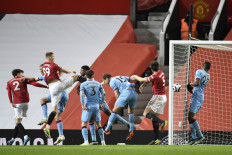 Manchester United's Scottish midfielder Scott McTominay (third left) and Manchester United's English defender Harry Maguire (second right) contest a crossed ball as the ball goes in for the opening goal credited as an own goal to West Ham United's English defender Craig Dawson (3R) during the English Premier League football match between Manchester United and West Ham United at Old Trafford in Manchester, north west England, on March 14, 2021.
