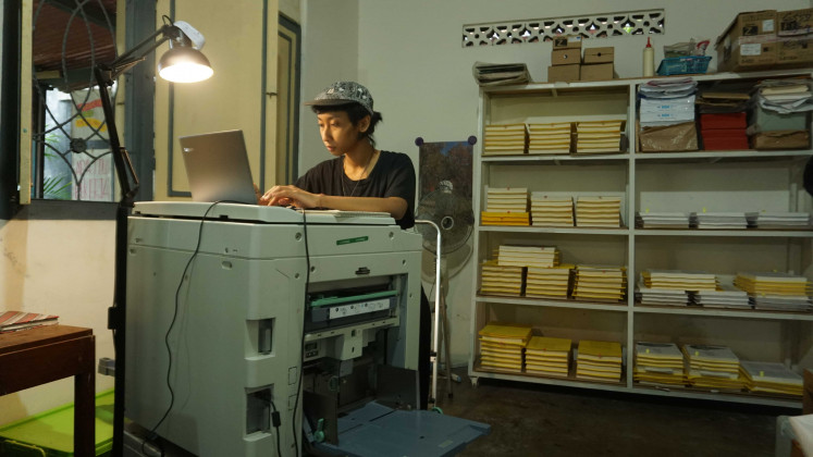 A Kunci Copy Station technician works on a Riso printer.