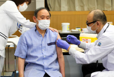 Japan's Prime Minister Yoshihide Suga (center) receives the COVID-19 vaccine at the National Center for Global Health and Medicine in Tokyo on March 16, 2021. 