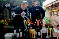 Yoyon Sukaryono (left) and Arief Kurniawan demonstrate their wine-making process.