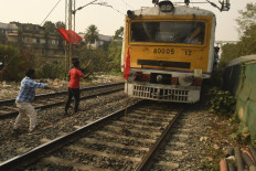 Leftist students stop a train to block the suburban railway service to protest against the central government's recent agricultural reforms, police brutality in West Bengal and the petrol price hike, in Kolkata on February 18, 2021.
