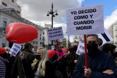 A man holds a placard reading 