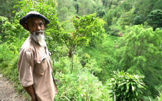 Sadiman, a 69-year-old ecowarrior, stands near a hill which is the first area he replanted with trees 20 years ago, in Wonogiri, Central Java province, Indonesia, in this still taken from March 13, 2021 video.
