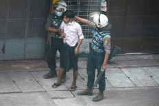 Gotcha: Riot police officers detain a demonstrator during a protest against the military coup in Yangon, Myanmar, on March 19. 