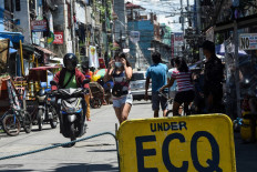 A policeman (right) monitors people at the entrance to a neighbourhood under strict quarantine measures in Pasay City, suburban Manila, on March 16, 2021, as the number of new daily cases of Covid-19 coronavirus has surged to the highest level in seven months. 