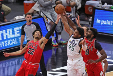 Donovan Mitchell #45 of the Utah Jazz battles for a rebound with Otto Porter Jr. #22 and Patrick Williams #9 of the Chicago Bulls at the United Center on March 22 in Chicago, Illinois. 