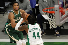 Giannis Antetokounmpo #34 of the Milwaukee Bucks takes a three point shot over Robert Williams III #44 of the Boston Celtics during the second half of a game at Fiserv Forum on March 24, 2021 in Milwaukee, Wisconsin.