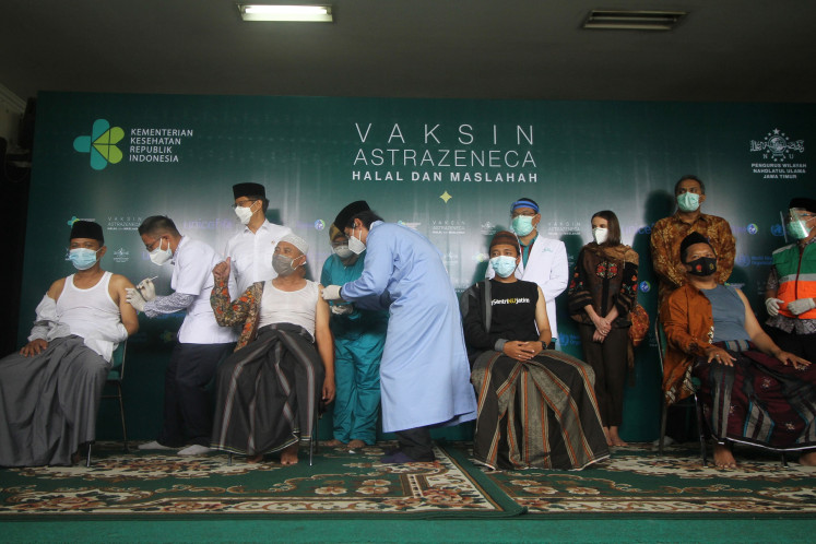 Health Minister Budi Gunadi Sadikin (third left) oversees the vaccination drive against young cleric from Nahdlatul Ulama (NU) in Surabaya, East Java on March 23. One-hundred NU young clerics are inoculated using the AstraZeneca vaccine, which is declared 'haram' (forbidden) by the Indonesian Ulema Council (MUI) for using pork-derivative product during its production.