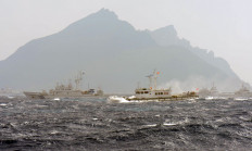 A Taiwan Coast Guard boat (right-with red flag) is blocked by a Japan Coast Guard vessel (left) in the waters near the disputed Diaoyu /Senkaku islands in the East China Sea on September 25, 2012. 
