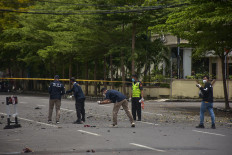 Forensic police investigate the site of a suspected suicide bombing outside a cathedral in Makassar, South Sulawesi, on Sunday.
