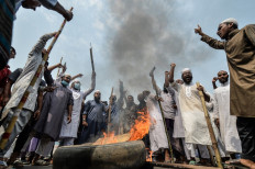 Activists from Hefazat-e Islam set fire to a tire and block a road during a nationwide strike following deadly clashes with police over Indian Prime Minister Narendra Modi’s visit, in Narayanganj, about 16 km southeast of Dhaka on March 28, 2021.
