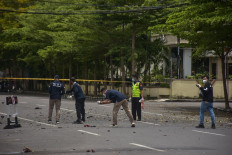 Indonesian forensic police examine the site after a suspected bomb exploded near a church in Makassar on March 28, 2021.

