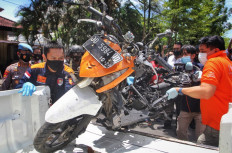 Indonesian police remove a motorcycle that was used by bombers during a reconstruction of the explosion in Makassar on March 29, 2021, one day after the suicide bombing at a cathedral on Palm Sunday.

