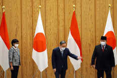 Japan's Prime Minister Yoshihide Suga (center) poses with Indonesian Foreign Minister Retno Marsudi (left) and Defense Minister Prabowo Subianto during a courtesy call at the prime minister's official residence in Tokyo on March 30, 2021.
