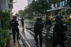 A police security team guard the entrance to the National Police Headquarters in South Jakarta on Wednesday, after gunfire was heard in the compound. 