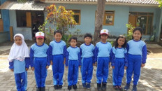 Elementary school students in a rural area in Indonesia pose for a photo. 