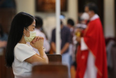 A congregant prays during a Good Friday service at the Catholic Church of Christ the King in Surabaya, East Java, on Friday. Attendants were required to adhere to the strict health protocols during the service to prevent the transmission of COVID-19.