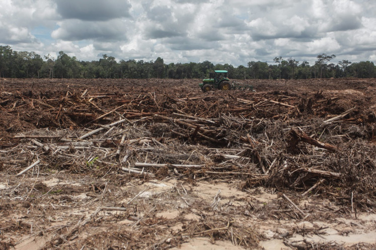 A worker uses a tractor on March 6, 2021 to plow land at the designated site of the food estate program in Tewai Baru, Gunung Mas regency, Central Kalimantan.