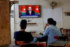 Jordanians follow the latest political developments in their country on a television set at a cafe in the capital Amman, on April 4, 2021. Jordan's official media warned today that security and stability are a 
