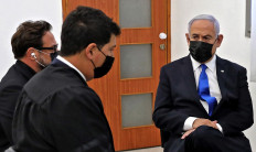 Israeli Prime Minister Benjamin Netanyahu (right) attends the hearing for his corruption trial at district court in Jerusalem on April 5, 2021. 