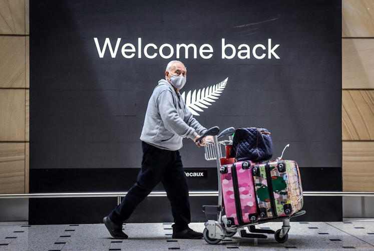 Seorang penumpang yang mengenakan masker tiba dari Selandia Baru di Bandara Internasional Sydney pada 16 Oktober 2020, setelah aturan perbatasan Australia dilonggarkan di bawah perjanjian perjalanan trans-Tasman satu arah baru yang memungkinkan pelancong dari Selandia Baru mengunjungi New South Wales tanpa harus untuk karantina di tengah pandemi coronavirus Covid-19.
